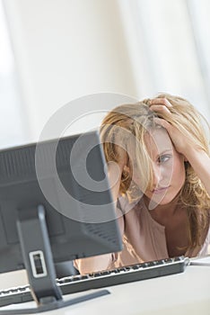 Frustrated Businesswoman Looking At Computer In Office