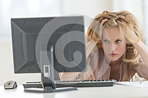 Frustrated Businesswoman Looking At Desktop PC In Office photo