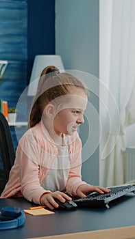 Frustrated child using computer and keyboard for homework