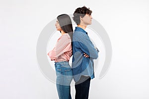 Frustrated couple standing back to back sulking on white background