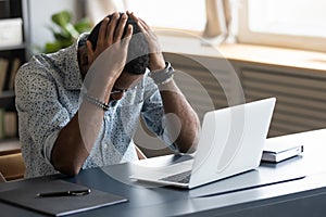 Frustrated depressed african businessman upset about business failure at work