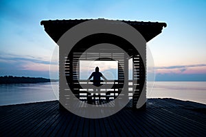 Frustrated depressed man wearing hoodie standing alone on wooden