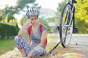 frustrated female cyclist has puncture