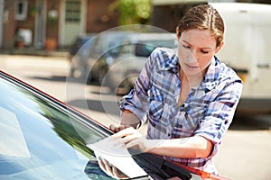 Frustrated Female Motorist Looking At Parking Ticket