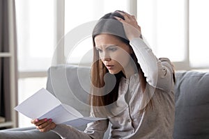 Frustrated girl shocked by bad news in letter