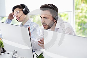 Frustrated helpdesk operator dealing with client`s problem in call centre