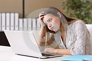 Frustrated intern working on line at office photo