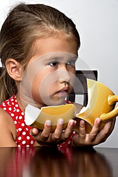 Frustrated little girl with a broken cup