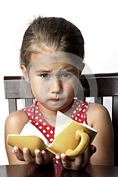 Frustrated little girl with a broken cup