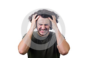 Frustrated, mad young man messing up and pulling his hair, hands to head, eyes closed screaming and clenching teeth isolated on photo