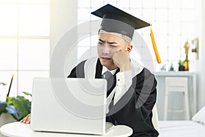 Frustrated male graduation trying to learn online at home