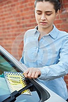 Frustrated Male Motorist Looking At Parking Ticket