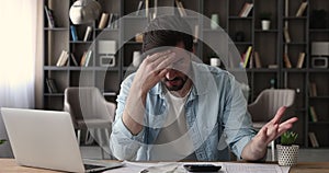 Frustrated man calculates finances feeling stressed about money lack