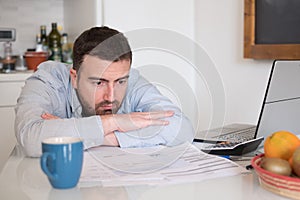 Frustrated man calculating bills and tax expenses