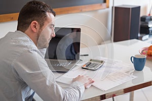 Frustrated man calculating bills and tax outcomes