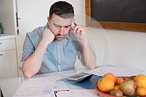 Frustrated man calculating bills and taxes expenses