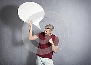 Frustrated man holding white blank speech bubble. photo
