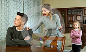 Frustrated man with irritated wife rebuking him