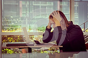 Frustrated man looking at laptop holding his hands to his head, Tired and worried business man at workplace