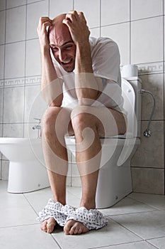 Frustrated man on toilet seat