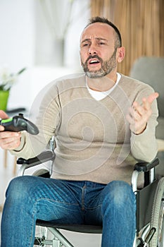 frustrated man in wheelchair playing computer games