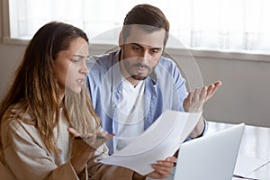 Frustrated married couple confused by paperwork from bank