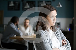 Frustrated millennial woman having no friends sitting alone in c