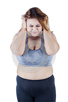 Frustrated overweight woman in studio