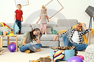 Frustrated parents and their mischievous children in room