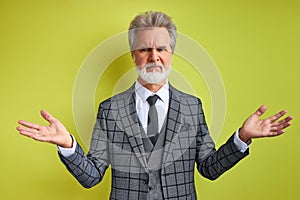 Frustrated rich businessman on green background
