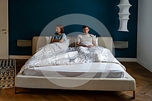 Disappointed woman consider break up divorce sad sit with crossed arms on bed ignore husband at home