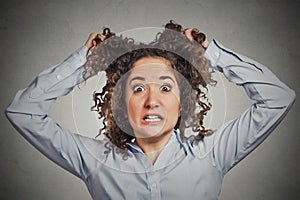 Frustrated shocked business woman pulling hair out yelling