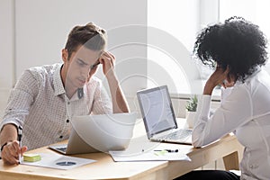 Frustrated stressed african and caucasian colleagues shocked abo