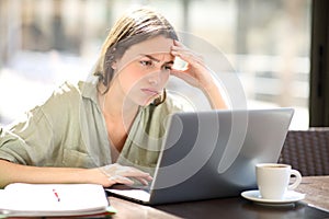 Frustrated student checking online on laptop