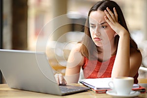 Frustrated student e-learning in a restaurant