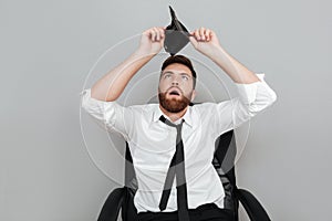 Frustrated surprised bearded man in white shirt showing empty wallet