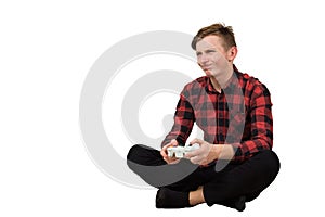 Frustrated teenage boy playing video games isolated over white background. Upset adolescent guy seadted on the floor holding a
