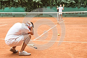 frustrated tennis player after fail on brown tennis