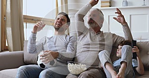 Frustrated three generations male family watching tv disappointed losing game