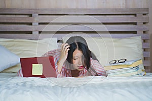 Frustrated and tired Asian Korean university student girl feeling overwhelmed and stressed preparing exam studying with laptop