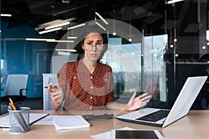 Frustrated and tired business woman looking at camera, Hispanic woman unhappy with work result, working inside office