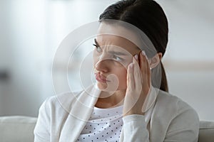 Frustrated unhealthy woman touching temples, suffering from strong headache.