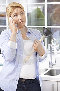 Frustrated Woman Calling Plumber To Fix Blocked Sink At Home