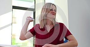 Frustrated woman crumples letter paper in office