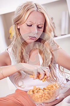 Frustrated woman eating chips