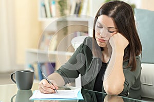 Frustrated woman filling form at home photo