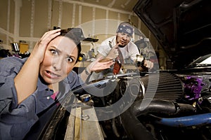 Frustrated woman with incompetent mechanic in back photo