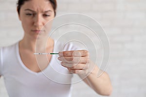 A frustrated woman shows a negative pregnancy test. The concept of female infertility. Human chorionic gonadotropin. One