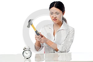 Frustrated woman smashing an alarm clock