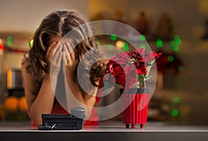Frustrated woman waiting for a phone call in Christmas kitchen